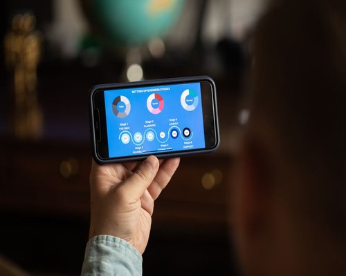 Smartphone displaying a fictional mobile game interface during a NimbusCrownBase technology exhibition