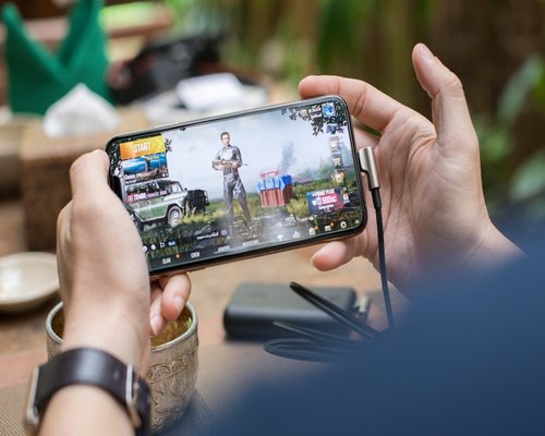 Mobile gaming demonstration shown on a primary smartphone screen inside an Australian technology showcase