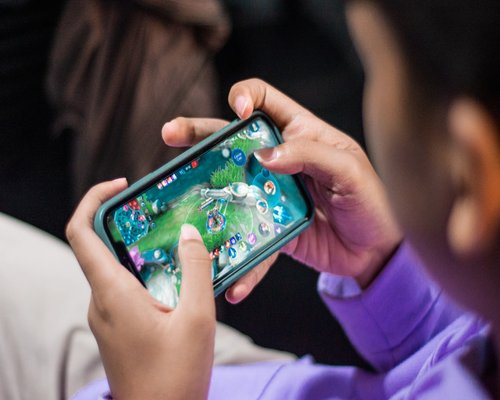 Smartphone with a beginner-friendly fictional game interface displayed horizontally during a gaming exhibition